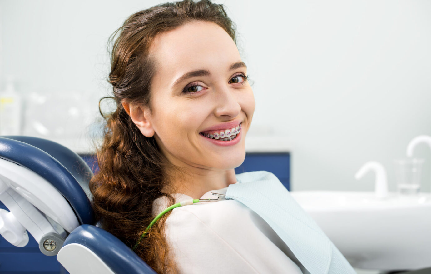 happy woman in braces smiling during examination in dental clinic